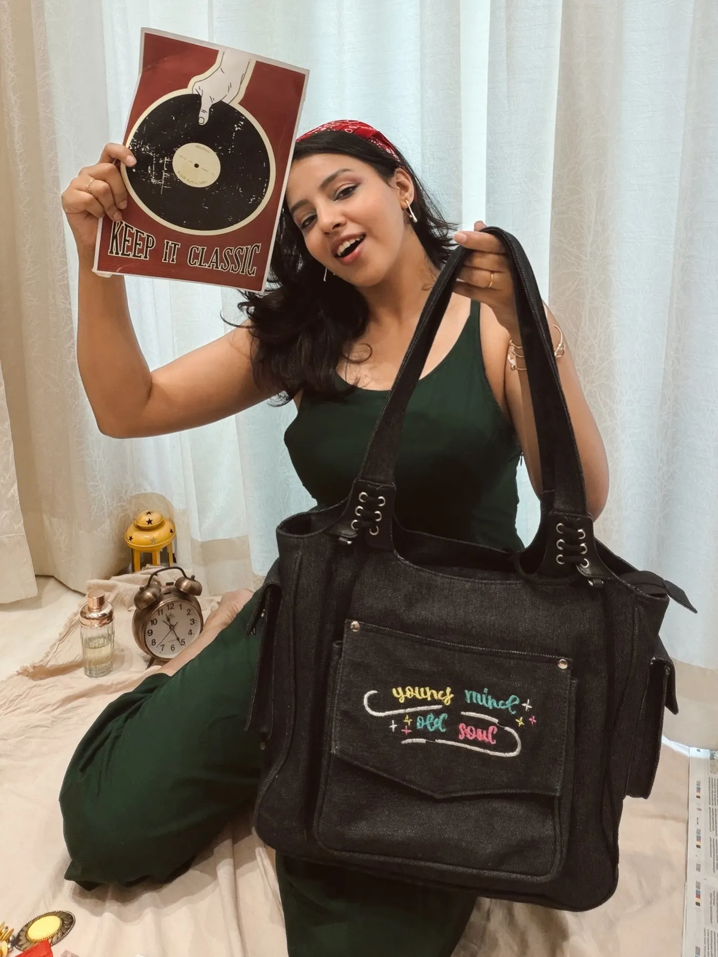 Model holding a vintage record with the black denim handbag on her shoulder